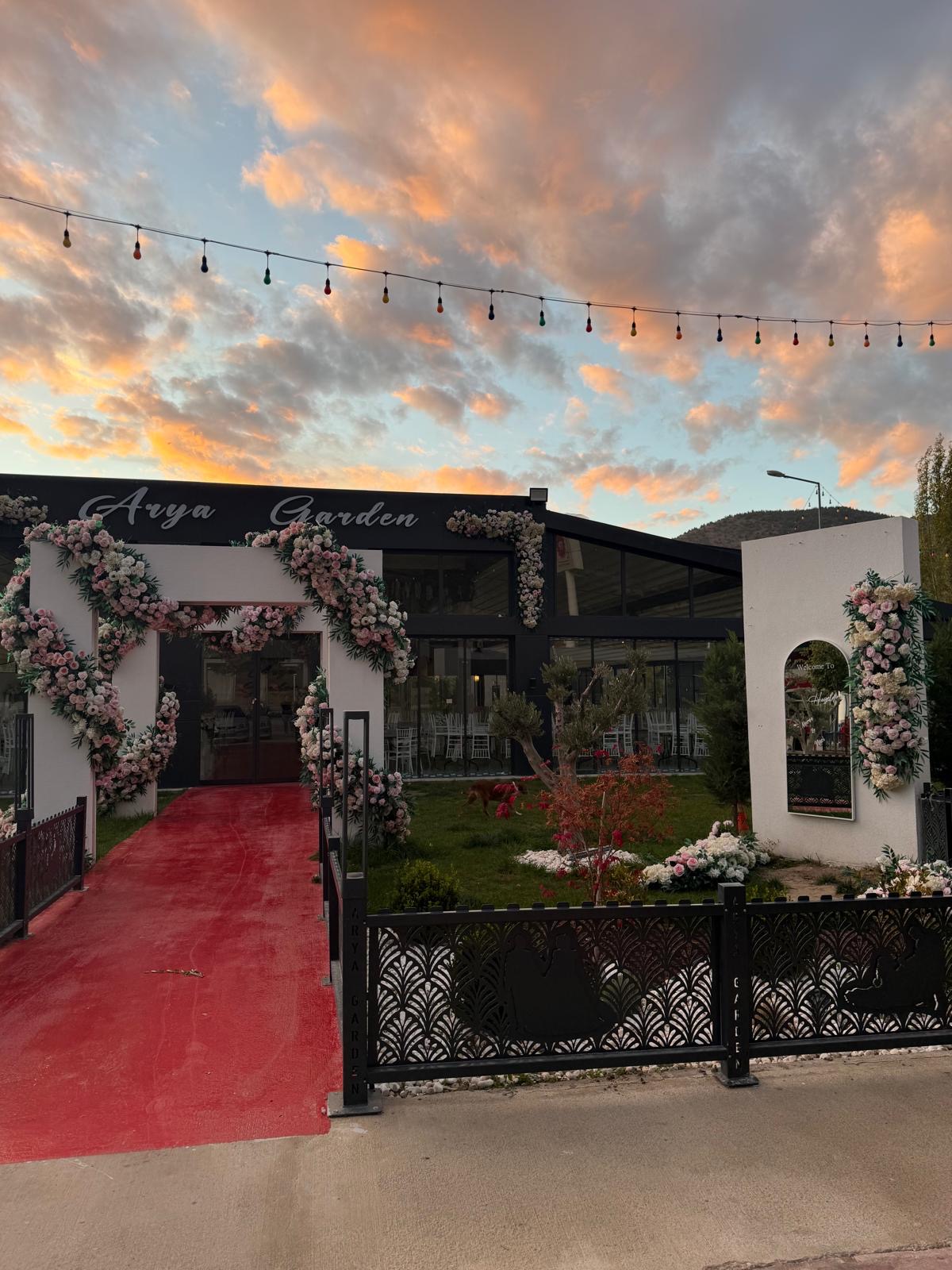 Arya Garden gün batımında çiçekli giriş kemeri